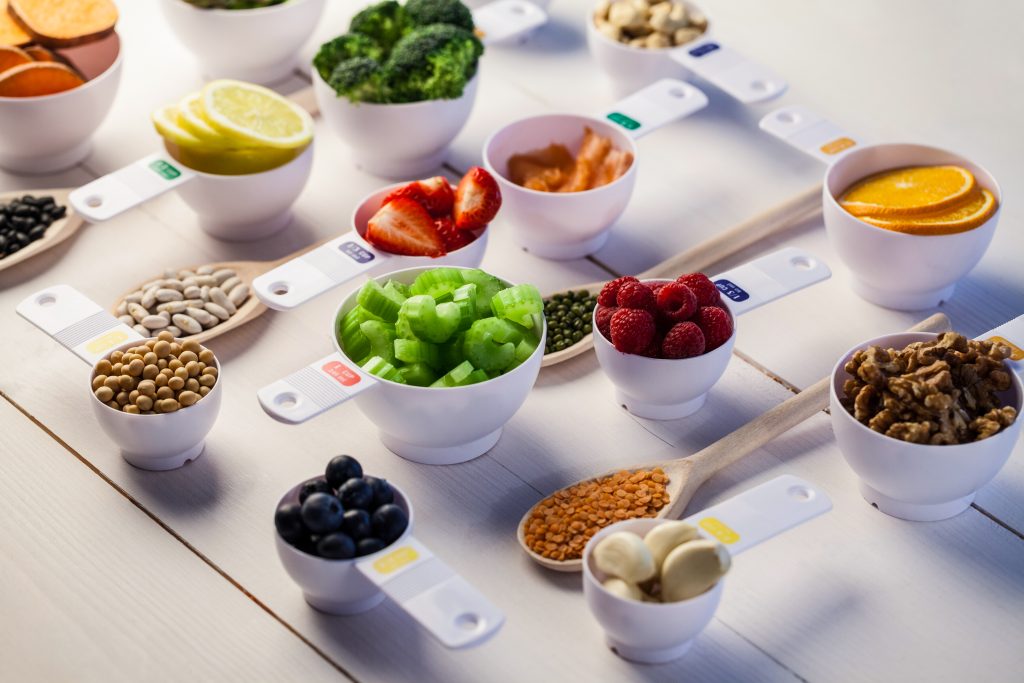 Assortiment de portions équilibrées d'aliments sains, illustrant une approche nutritionnelle à Bourgoin